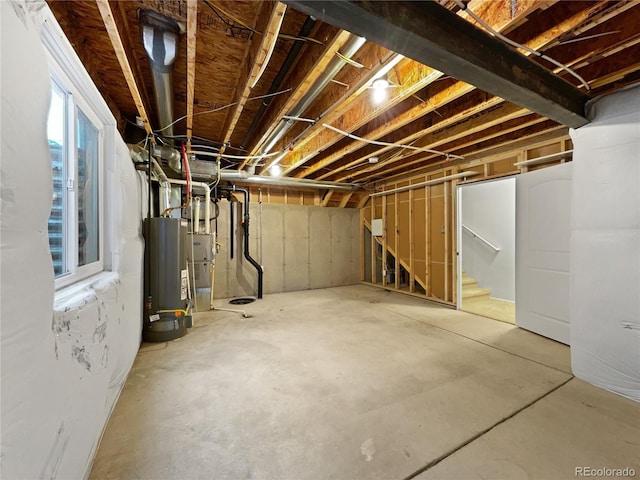 basement featuring water heater and stairs