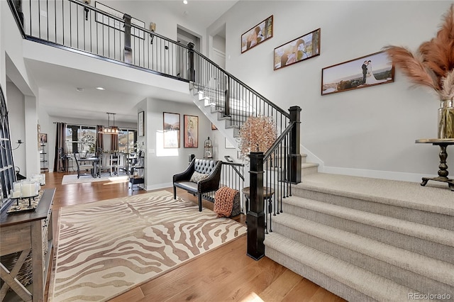 stairs featuring a high ceiling and wood-type flooring