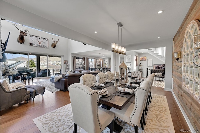 dining area with light hardwood / wood-style floors and an inviting chandelier