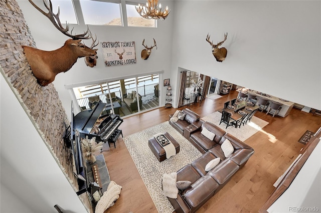 living room featuring a chandelier, a high ceiling, and light hardwood / wood-style flooring