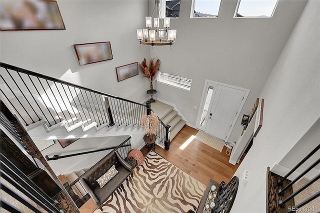 entrance foyer featuring a high ceiling, hardwood / wood-style floors, and an inviting chandelier