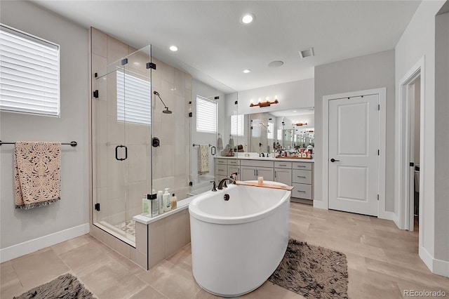 bathroom with tile patterned flooring, vanity, and plus walk in shower