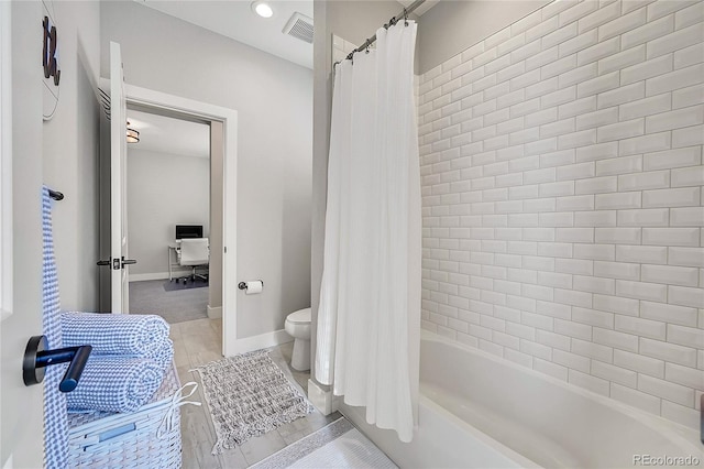 bathroom with toilet and shower / tub combo with curtain