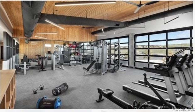 workout area featuring wood ceiling, a towering ceiling, and wooden walls