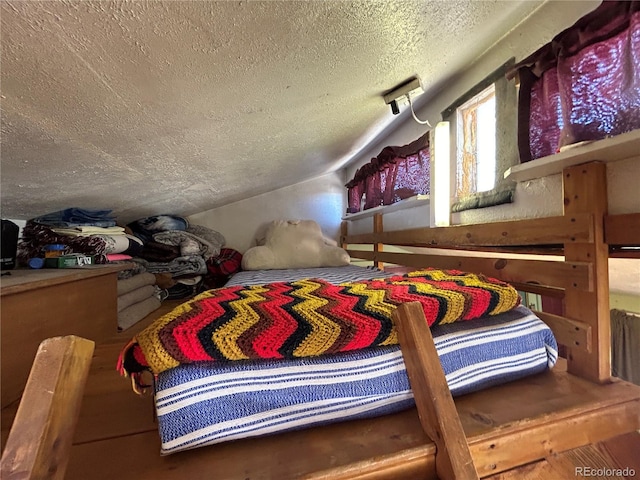 bedroom featuring vaulted ceiling and a textured ceiling
