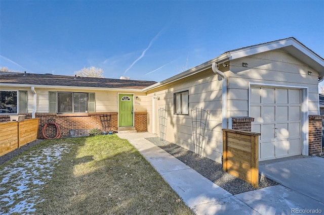 ranch-style home featuring a garage and a front lawn