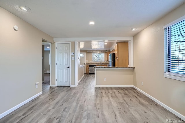 kitchen featuring kitchen peninsula, a healthy amount of sunlight, and stainless steel appliances