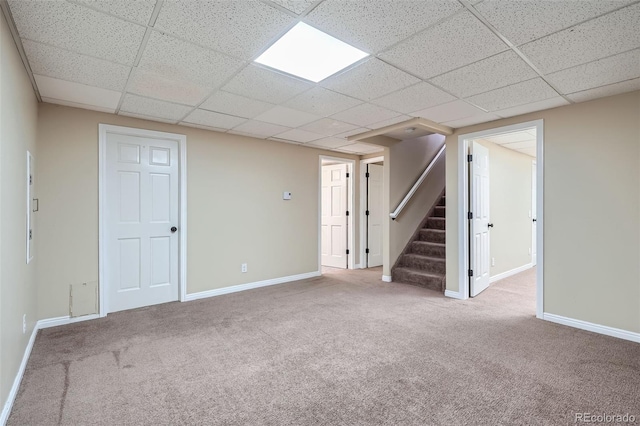 basement featuring a paneled ceiling and carpet floors