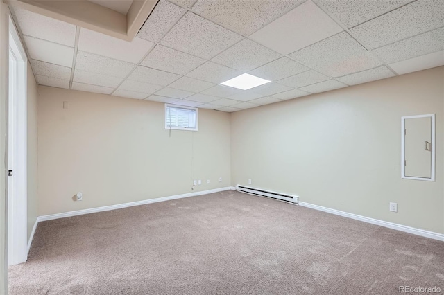 basement featuring carpet, a paneled ceiling, baseboard heating, and electric panel