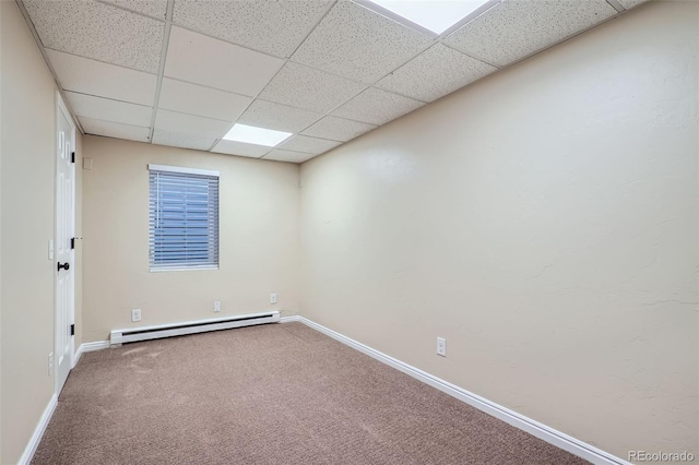 empty room featuring carpet floors, a baseboard radiator, and a paneled ceiling