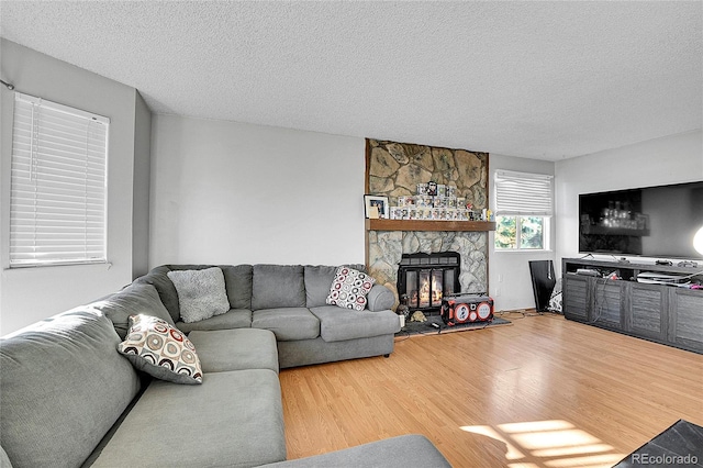 living room featuring hardwood / wood-style floors, a fireplace, and a textured ceiling