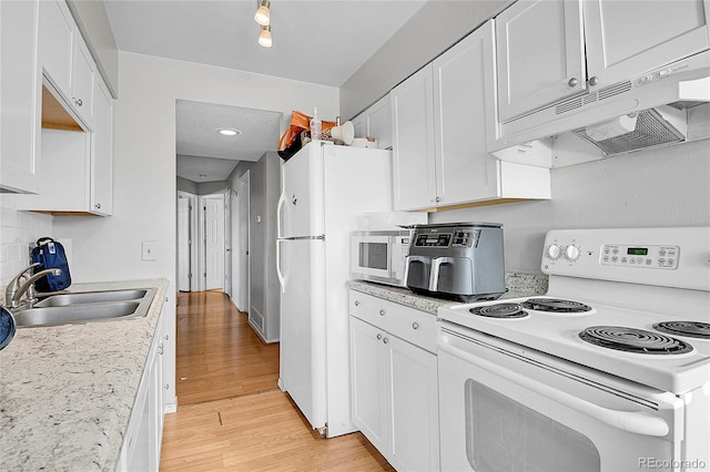 kitchen featuring sink, tasteful backsplash, light hardwood / wood-style floors, white appliances, and white cabinets