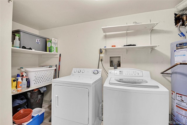 laundry room with water heater and washing machine and clothes dryer