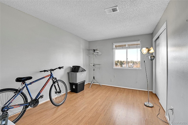 miscellaneous room with hardwood / wood-style floors and a textured ceiling