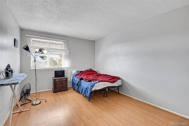 bedroom with wood-type flooring and a textured ceiling