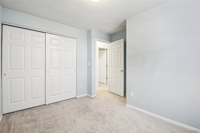 unfurnished bedroom featuring light colored carpet, a closet, and a textured ceiling