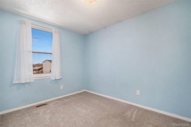 unfurnished room featuring a textured ceiling and carpet