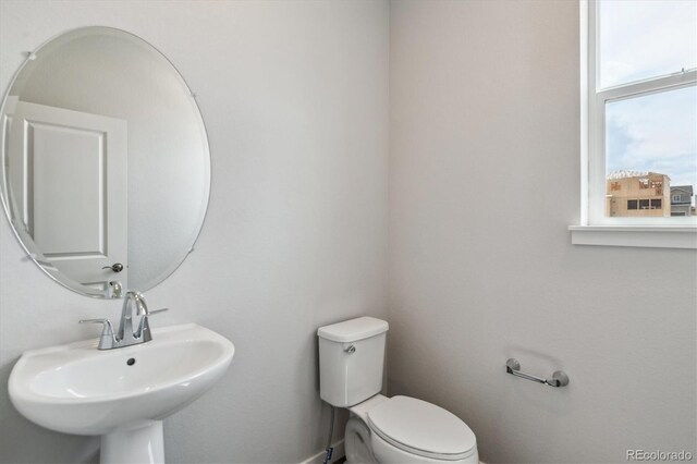 14145 Deertrack Ln, Parker, CO 80134 - half bathroom with a sink, toilet, and baseboards