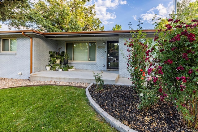 7650 W 24th Ave, Lakewood, CO 80214 - view of front facade featuring brick siding, covered porch, and a front yard
