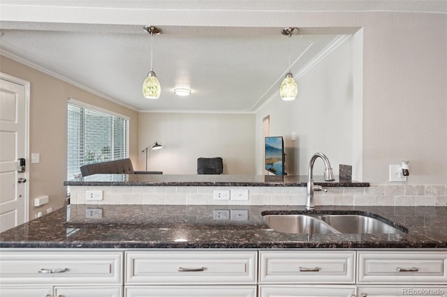 7650 W 24th Ave, Lakewood, CO 80214 - kitchen with crown molding, dark stone counters, decorative light fixtures, and white cabinetry