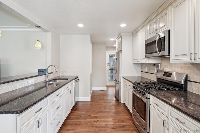7650 W 24th Ave, Lakewood, CO 80214 - kitchen featuring stainless steel appliances, tasteful backsplash, wood finished floors, dark stone counters, and recessed lighting