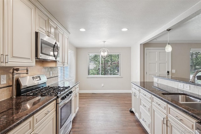 7650 W 24th Ave, Lakewood, CO 80214 - kitchen with stainless steel appliances, decorative backsplash, dark wood-style floors, recessed lighting, and a textured ceiling