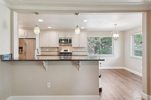 7650 W 24th Ave, Lakewood, CO 80214 - kitchen featuring stainless steel appliances, a breakfast bar area, backsplash, light wood-style flooring, and dark stone counters