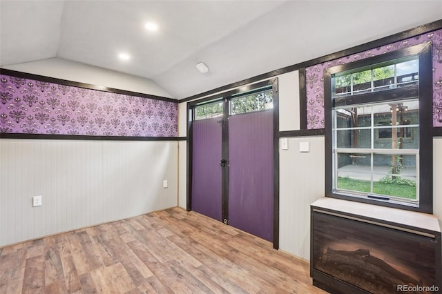 7650 W 24th Ave, Lakewood, CO 80214 - foyer with wood finished floors, lofted ceiling, wainscoting, healthy amount of natural light, and wallpapered walls