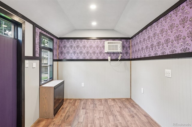 7650 W 24th Ave, Lakewood, CO 80214 - empty room with wood finished floors, wallpapered walls, wainscoting, lofted ceiling, and an AC wall unit