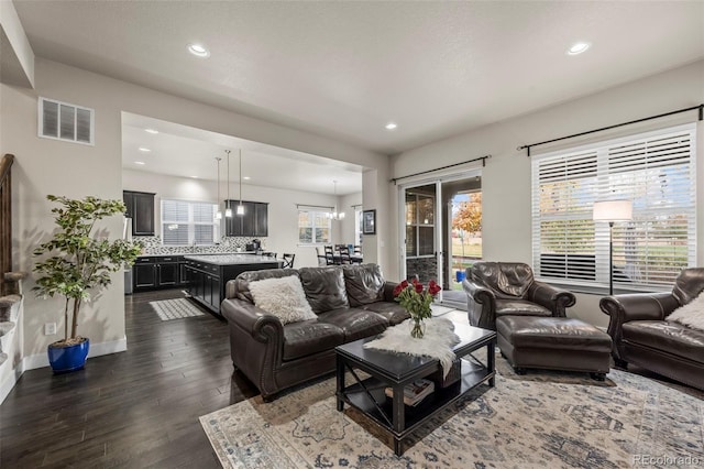 living area with visible vents, recessed lighting, dark wood-type flooring, and a wealth of natural light
