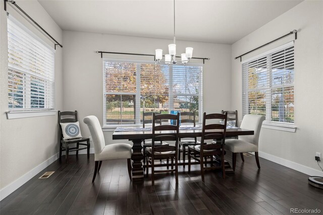 dining area with baseboards, an inviting chandelier, and wood finished floors