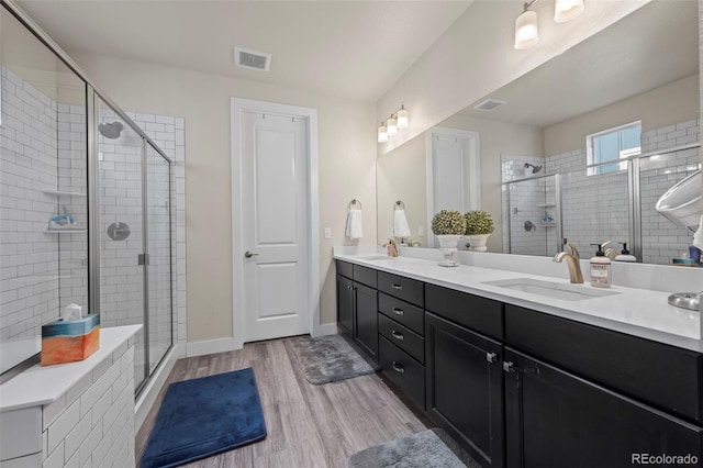 bathroom with visible vents, a sink, and a shower stall
