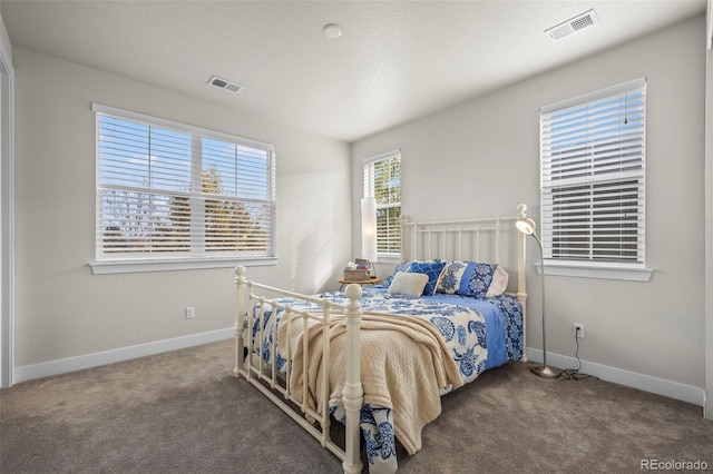 carpeted bedroom with visible vents and baseboards