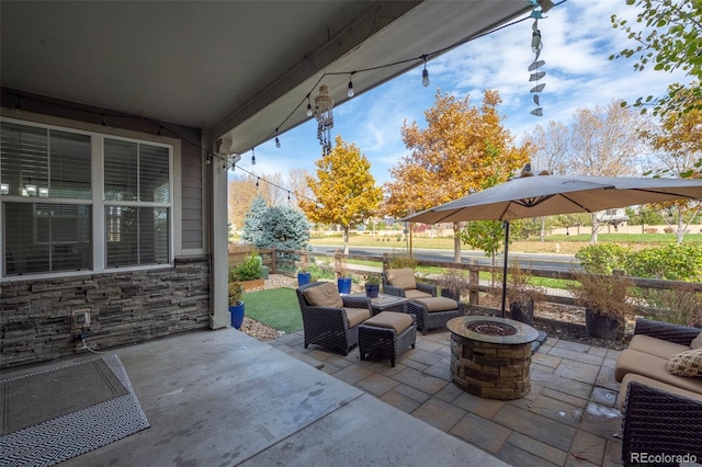 view of patio featuring fence and an outdoor living space with a fire pit