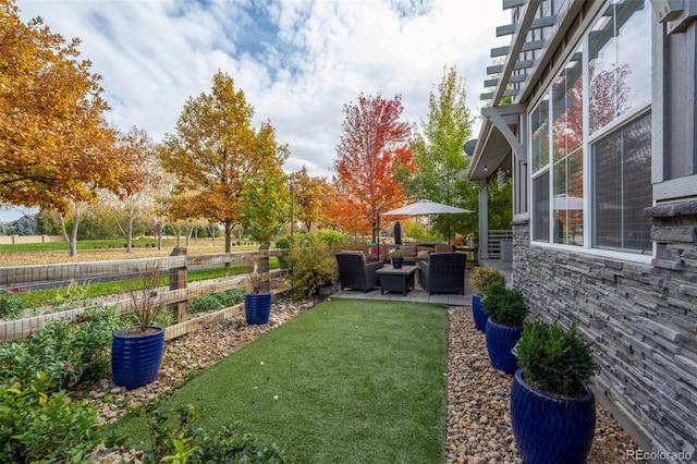 view of yard featuring an outdoor living space, fence, and a patio