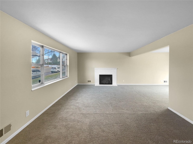 unfurnished living room featuring carpet floors and a brick fireplace