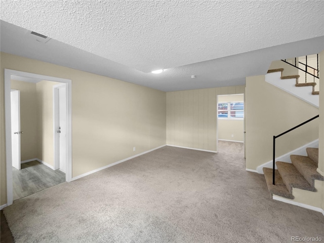 carpeted empty room featuring a textured ceiling