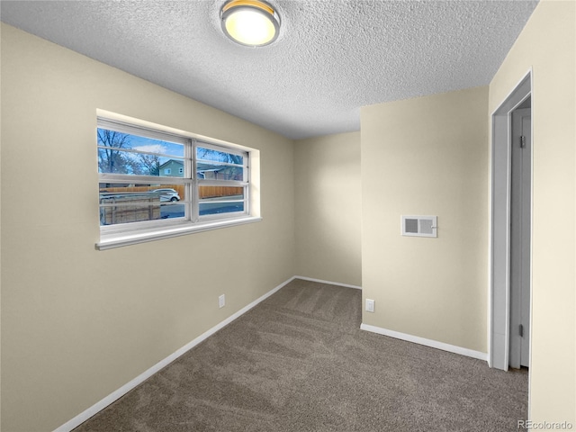 empty room featuring carpet and a textured ceiling