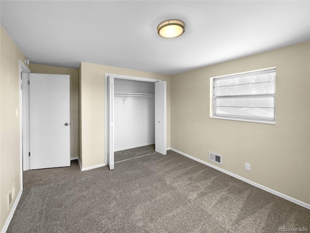 unfurnished bedroom featuring a closet and dark carpet