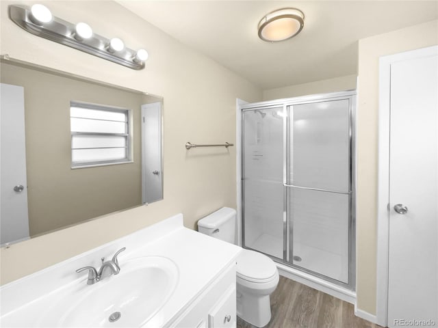 bathroom featuring toilet, vanity, wood-type flooring, and walk in shower