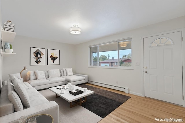 living room featuring baseboard heating and light hardwood / wood-style floors