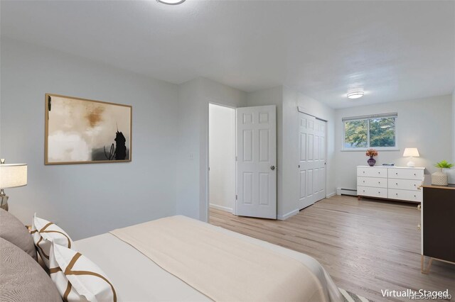 8467 W 62nd Pl, Arvada, CO 80004 - bedroom with a closet, baseboards, a baseboard heating unit, and light wood-type flooring
