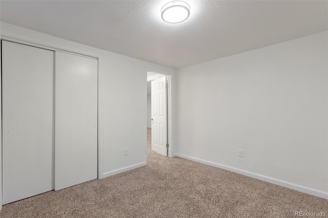 unfurnished bedroom featuring a closet, carpet flooring, and a textured ceiling