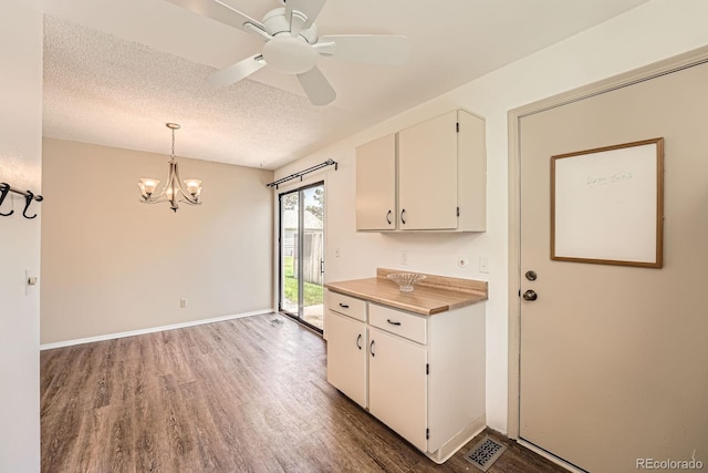 kitchen featuring wood finished floors, a chandelier, white cabinetry, light countertops, and a textured ceiling