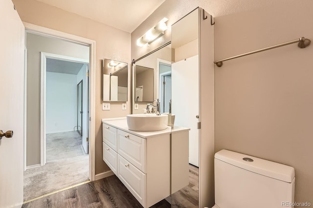 bathroom featuring wood finished floors, vanity, and baseboards
