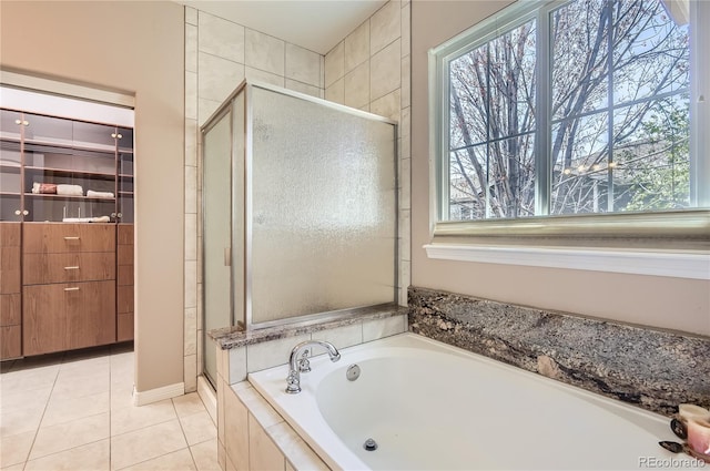 bathroom with a shower stall, a bath, and tile patterned flooring