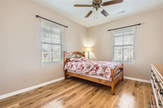 bedroom featuring baseboards, a ceiling fan, visible vents, and light wood-type flooring
