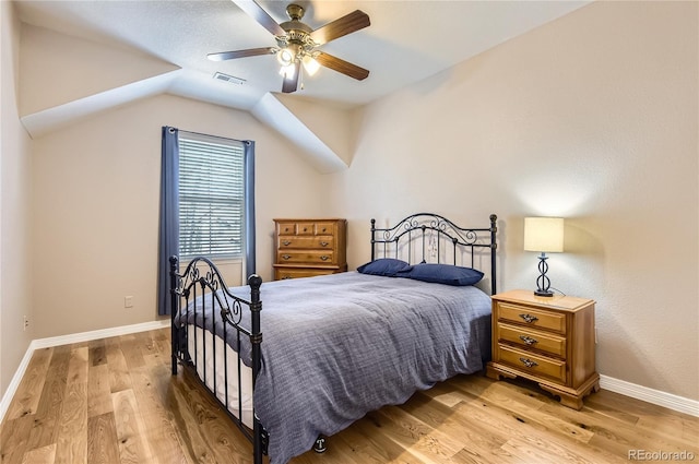 bedroom with ceiling fan, light wood finished floors, baseboards, lofted ceiling, and visible vents