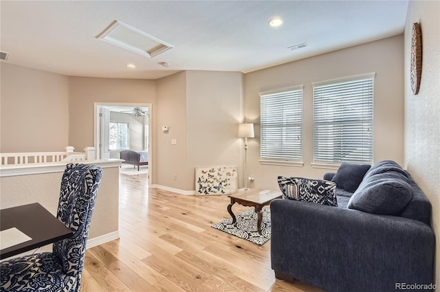 living room featuring attic access, light wood-type flooring, baseboards, visible vents, and recessed lighting