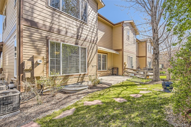 exterior space featuring fence, a patio, a yard, and cooling unit